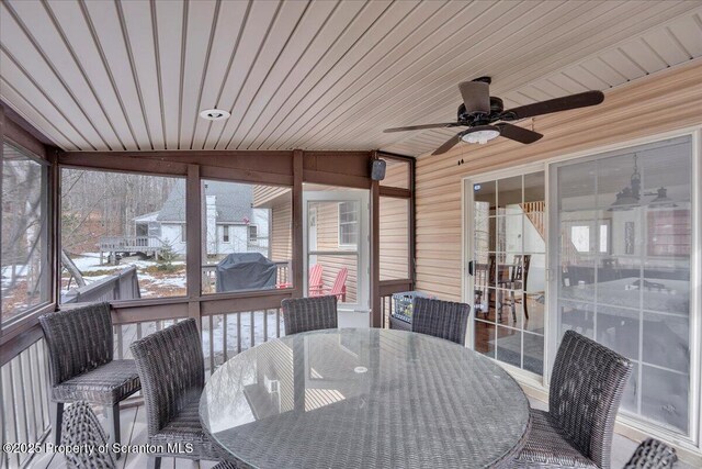 sunroom with ceiling fan and wood ceiling