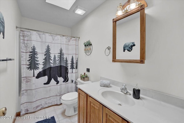 bathroom with toilet, a skylight, a shower with shower curtain, and vanity