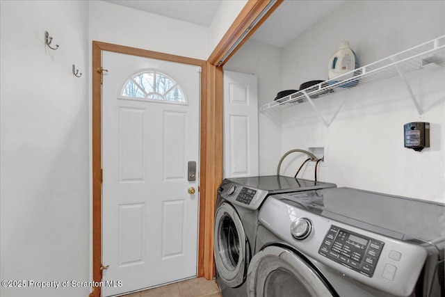 washroom with laundry area, washing machine and clothes dryer, and light tile patterned floors