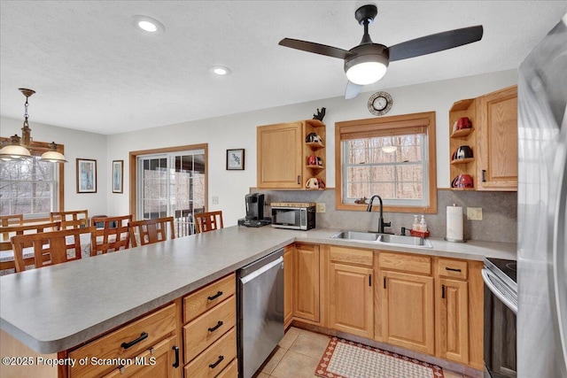 kitchen with tasteful backsplash, appliances with stainless steel finishes, a peninsula, open shelves, and a sink