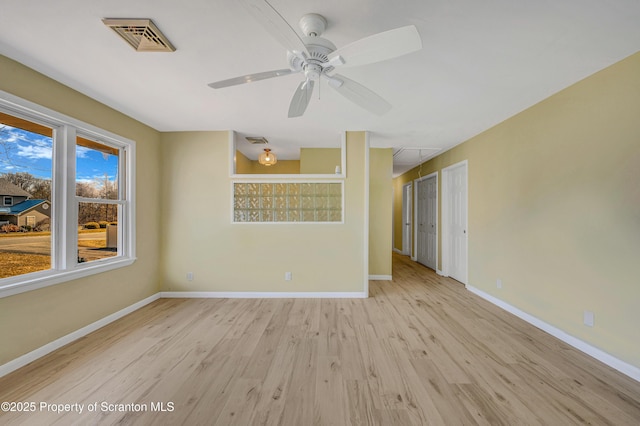 unfurnished room with attic access, wood finished floors, visible vents, and baseboards