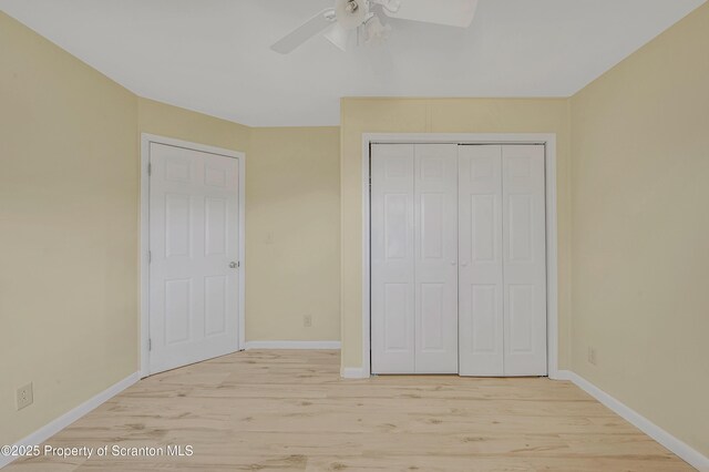 unfurnished bedroom with light wood finished floors, baseboards, a closet, and a ceiling fan