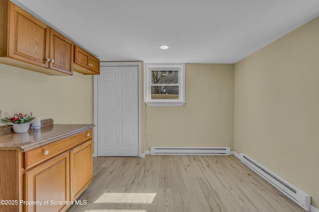 interior space with recessed lighting, a baseboard heating unit, and light wood-style floors