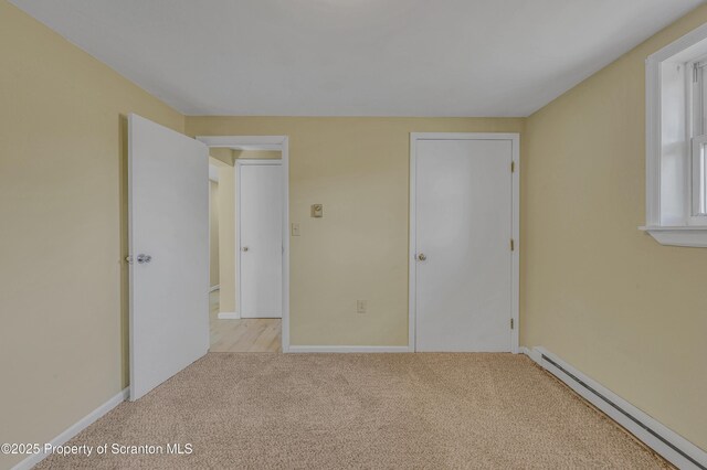 carpeted empty room with baseboard heating