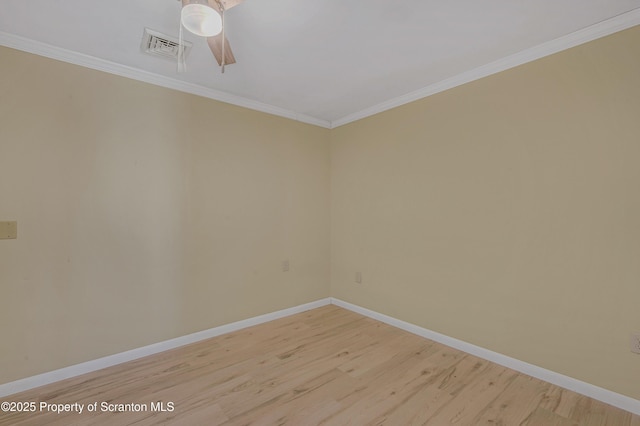 empty room with visible vents, baseboards, light wood-style floors, and ornamental molding