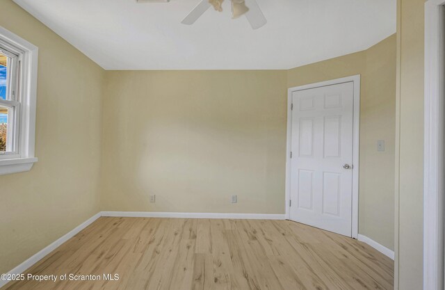 unfurnished room with ceiling fan, light wood-type flooring, and baseboards