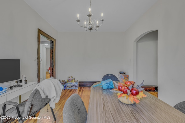 dining space featuring wood-type flooring and a notable chandelier