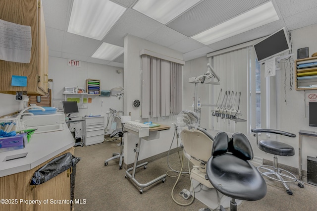 interior space with a paneled ceiling and sink