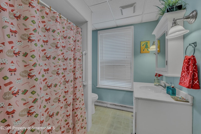 bathroom featuring baseboard heating, vanity, toilet, a shower with shower curtain, and a drop ceiling