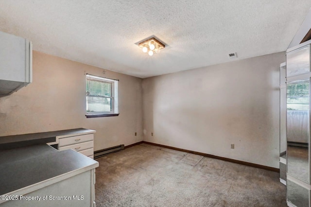 interior space featuring a textured ceiling, baseboard heating, and plenty of natural light