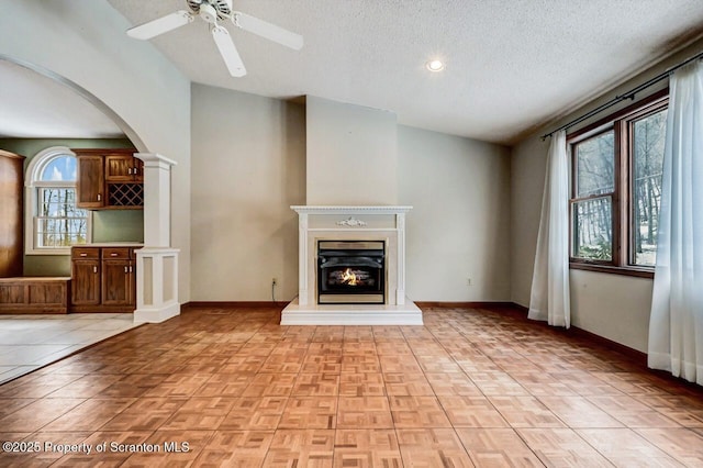 unfurnished living room featuring lofted ceiling, a textured ceiling, and a healthy amount of sunlight