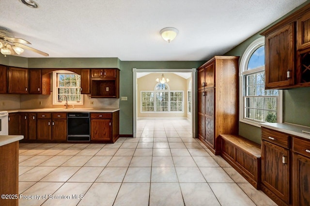 kitchen featuring a textured ceiling, range, light tile patterned floors, ceiling fan with notable chandelier, and black dishwasher