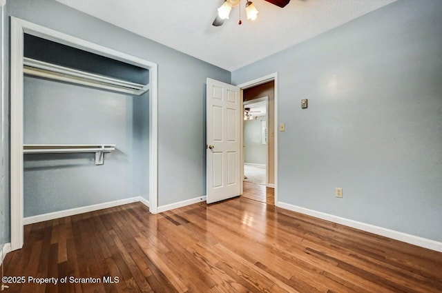 unfurnished bedroom with wood-type flooring, a closet, and ceiling fan