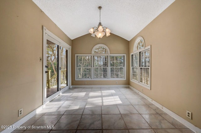 unfurnished dining area with a textured ceiling, tile patterned flooring, an inviting chandelier, and vaulted ceiling