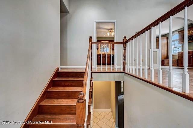 stairs featuring tile patterned floors and ceiling fan