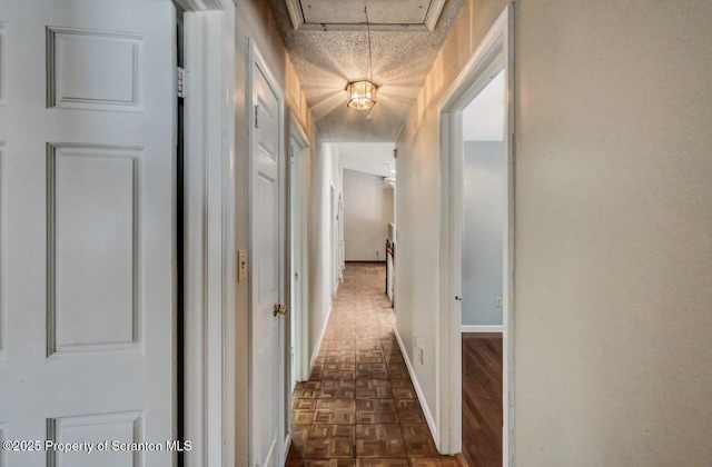 corridor featuring a textured ceiling and dark parquet floors