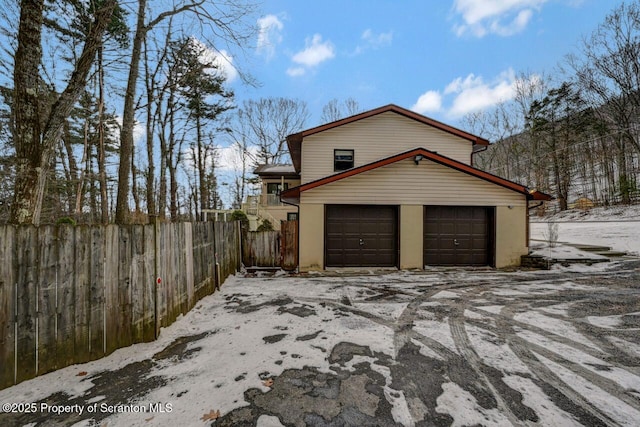 snow covered property with a garage