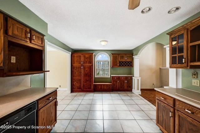 kitchen with ceiling fan, dishwasher, light tile patterned floors, and ornate columns