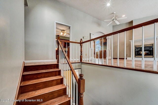 stairway featuring ceiling fan