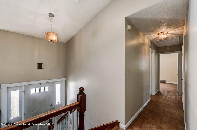 foyer with dark parquet flooring, a chandelier, and a textured ceiling