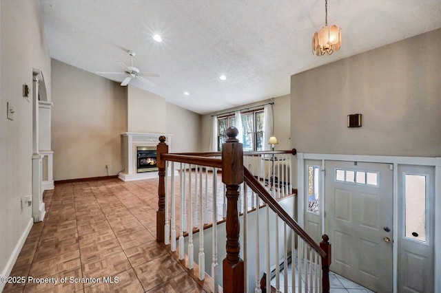 interior space featuring a textured ceiling, ceiling fan with notable chandelier, vaulted ceiling, and parquet floors