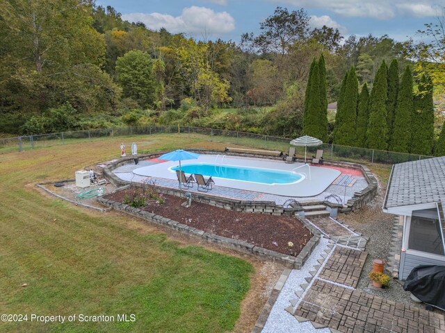 view of swimming pool featuring a lawn