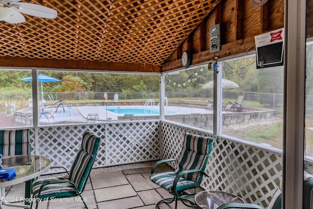 unfurnished sunroom with ceiling fan and lofted ceiling