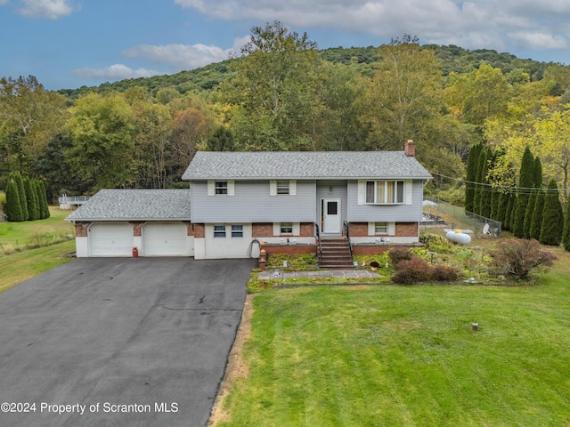 bi-level home featuring a front lawn and a garage