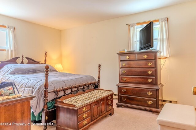 bedroom featuring light colored carpet and a baseboard heating unit