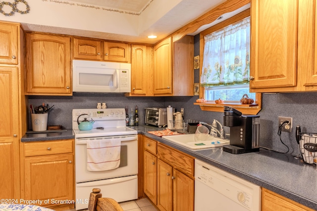 kitchen featuring light tile patterned floors, white appliances, backsplash, and sink