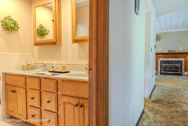 bathroom with tile patterned floors, a premium fireplace, vanity, and tile walls