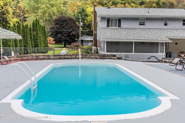 view of swimming pool with a sunroom