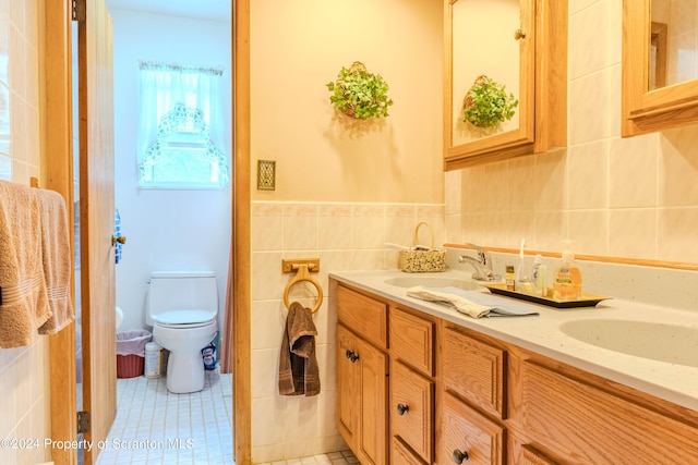 bathroom with tile patterned flooring, vanity, tile walls, and toilet