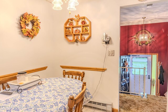 dining area with a baseboard radiator and a notable chandelier