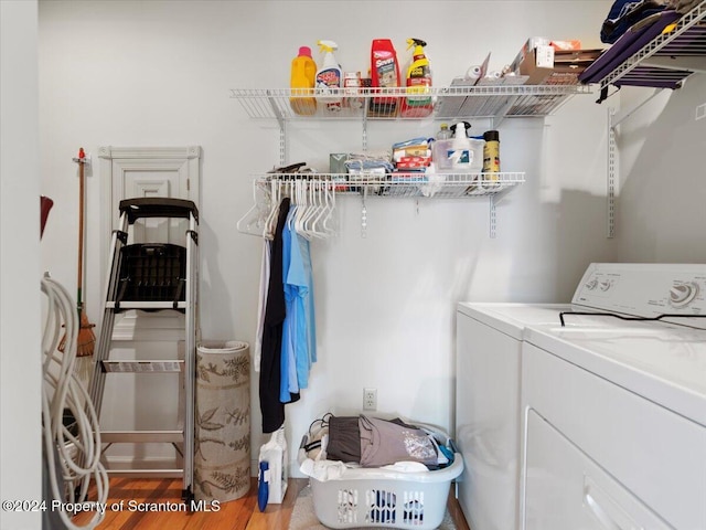 laundry area with washer and clothes dryer and light hardwood / wood-style floors