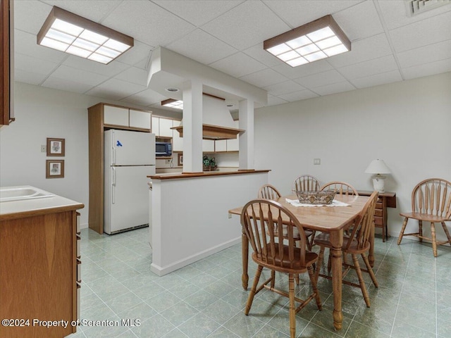 dining room with a paneled ceiling and sink