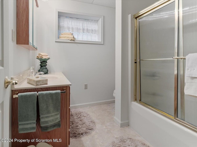 full bathroom with vanity, bath / shower combo with glass door, and toilet