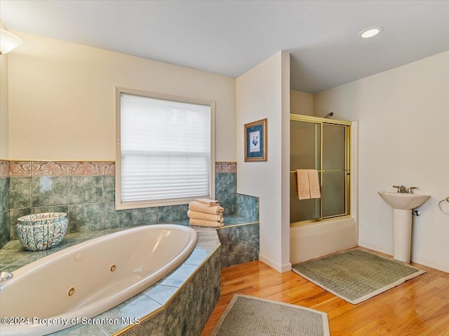 bathroom featuring hardwood / wood-style floors and plus walk in shower