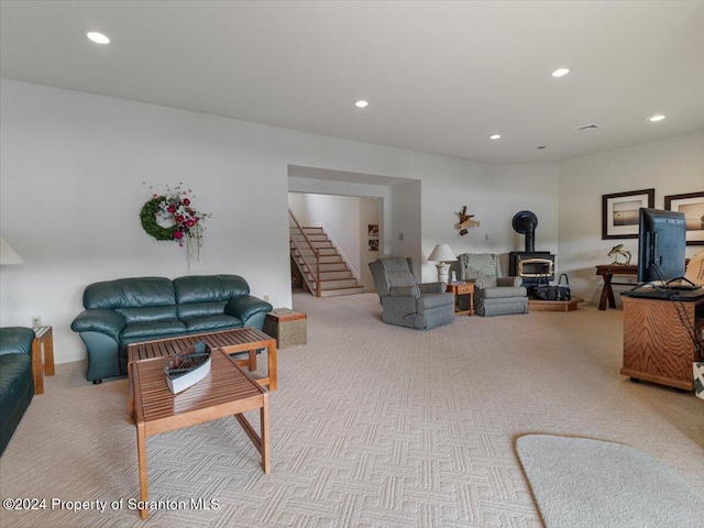 living room with a wood stove and light colored carpet