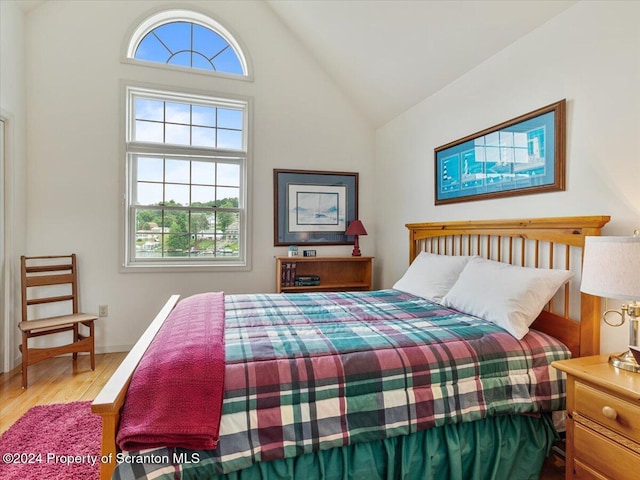 bedroom with vaulted ceiling and hardwood / wood-style flooring