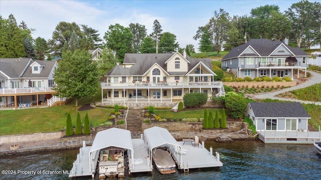 back of property featuring a water view, a yard, and a balcony