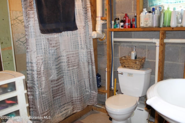 bathroom featuring walk in shower, tile patterned floors, and toilet