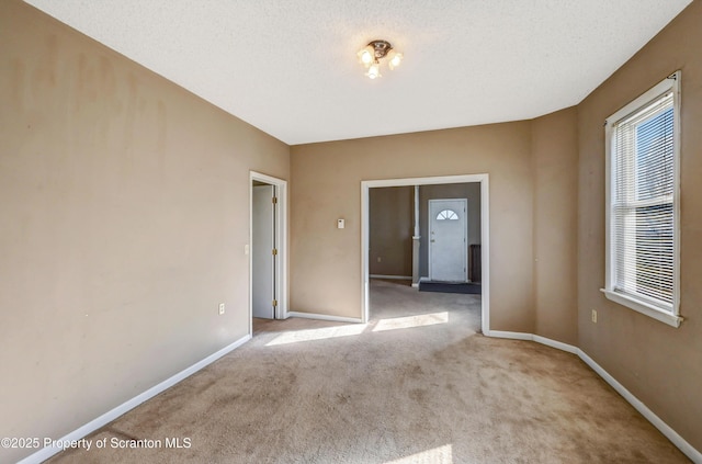 unfurnished room featuring baseboards and carpet