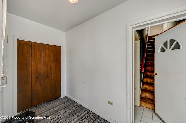 unfurnished bedroom featuring baseboards, a closet, and light colored carpet
