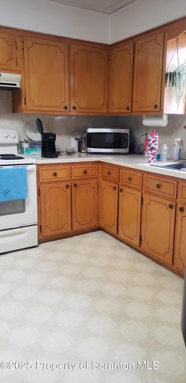 911 Prince St, Taylor, PA 18517 - kitchen with white range with electric cooktop, stainless steel microwave, ventilation hood, and light countertops