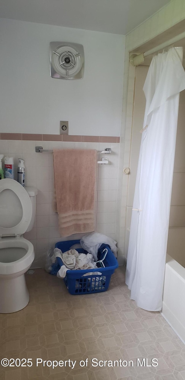 911 Prince St, Taylor, PA 18517 - full bath featuring tile walls, shower / bath combo, and wainscoting