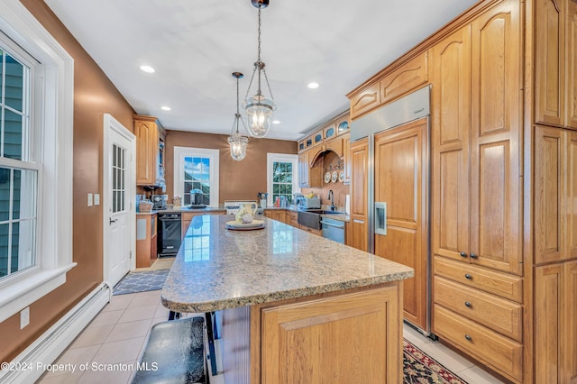 kitchen with paneled refrigerator, baseboard heating, light tile patterned floors, a center island, and hanging light fixtures