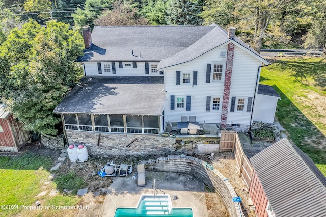 rear view of house with a sunroom and a patio