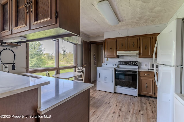 505 Yedinak Ln, Madison Twp, PA 18444 - kitchen featuring white appliances, under cabinet range hood, washer / clothes dryer, light wood-style floors, and light countertops