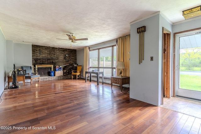 505 Yedinak Ln, Madison Twp, PA 18444 - living room with ceiling fan, wood finished floors, ornamental molding, and a fireplace